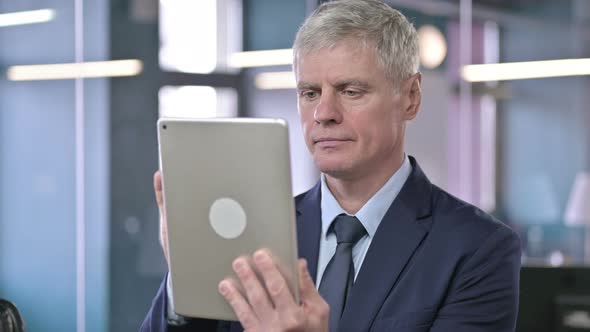 Portrait of Middle Aged Businessman Using Tablet