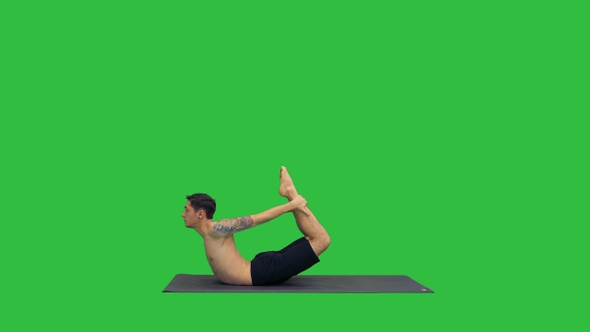 Sporty muscular young yogi man doing backbend exercise