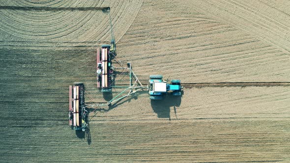 Agricultural Vehicle Is Sowing the Land in the Field in a Top View
