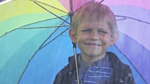 Boy with Umbrella Standing in Rain