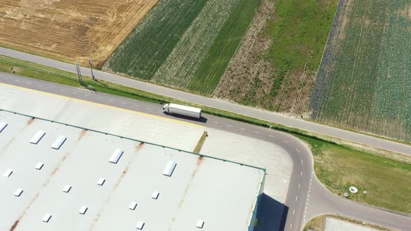 Aerial Shot of Industrial Warehouse Loading Dock where Many Truck with Semi Trailers Load Merchandis