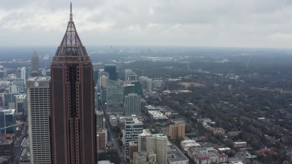 Drone shot above Midtown Atlanta on a cloudy day after a storm. Pushing in from Downtown past Bank o