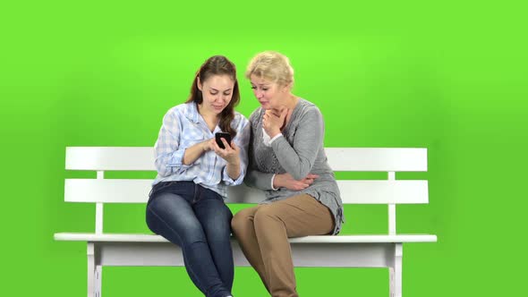 Girl Shows Something in the Phone To Her Mother. Green Screen