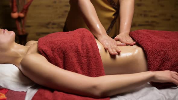 Young woman at a session of a healing massage of the abdomen and internal organs