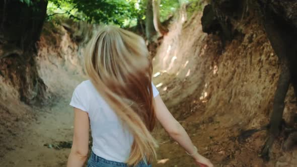 Back View of Pretty Blonde Woman Running in Roots Gorge