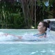 Beautiful Young Woman Relaxes in a Hydromassage Jacuzzi in Swimming Pool - VideoHive Item for Sale