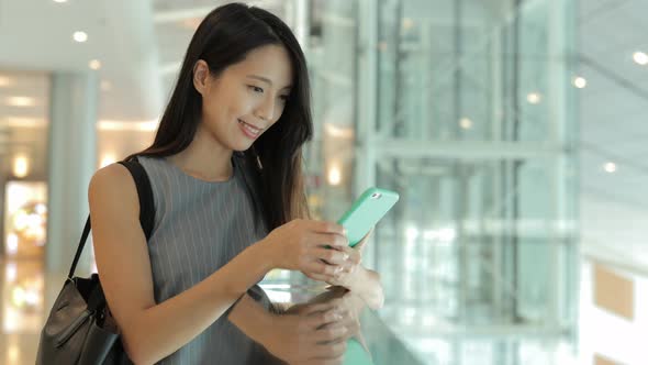 Woman using mobile phone in shopping mall