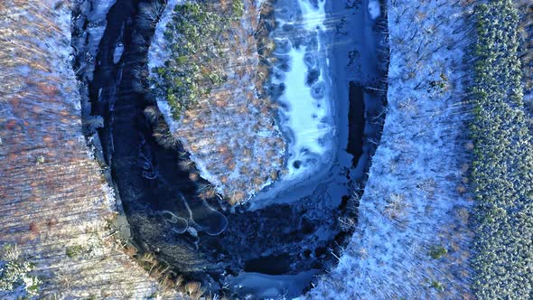 Aerial view of wildlife in Poland. Winter river and forest.