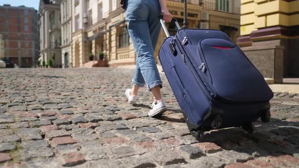 Beautiful Young Woman Tourist with Suitcase in the City Center