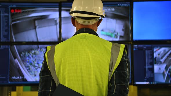 Engineer in Front of Facility Control Room Displays