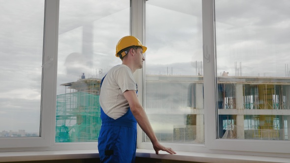 Worker looking at construction site though the window.