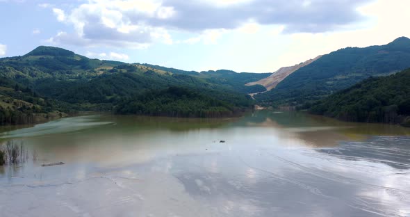 Sunken Village Of Geamana In A Toxic Lake Surrounded With Apuseni Mountains In Romania. aerial