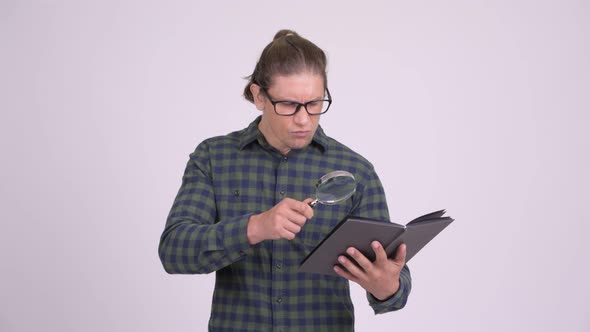 Handsome Hipster Man Reading Book with Magnifying Glass