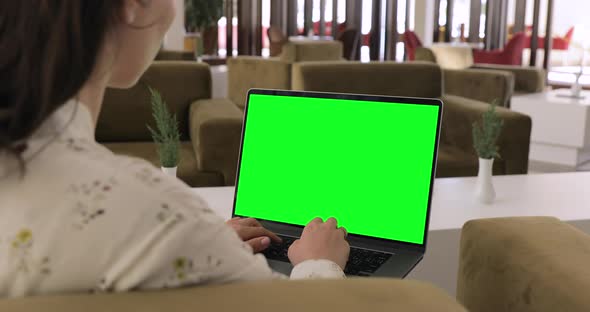 Girl working on Green Screen Mock Up Laptop. Sunny Modern Interior Great for Distance Remote work.