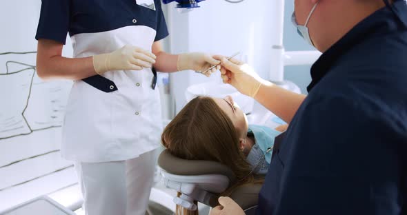 the Dentist Performs an Examination Using a Dental Mirror a Woman