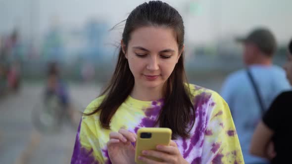 Portrait of Pretty Woman Typing By Mobile Phone Outdoors