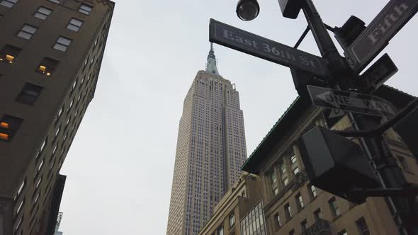 Low Angle Pan Shot Midtown Manhattan Street Signs and the Empire State Building