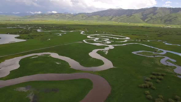 Winding river flowing through green valley in Wyoming