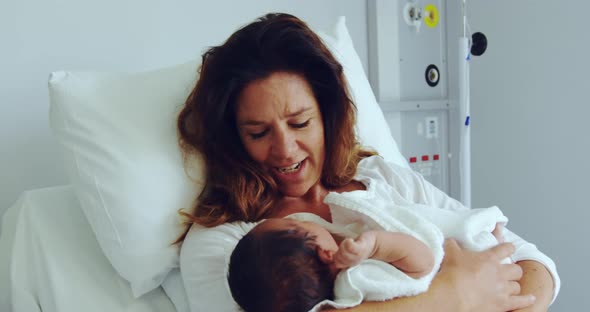 Front view of Caucasian mother holding her newborn baby in the ward at hospital