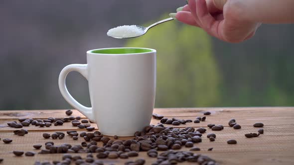 Cup of Hot Coffee Stands By the Window Releases Steam and Put Sugar with Spoon