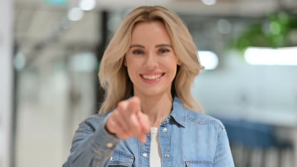 Smiling Young Casual Woman Pointing at the Camera