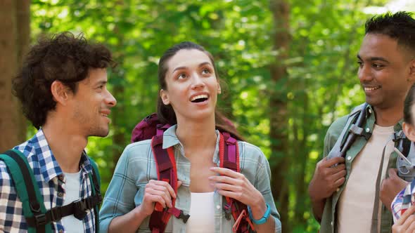 Friends with Backpacks on Hike Talking in Forest