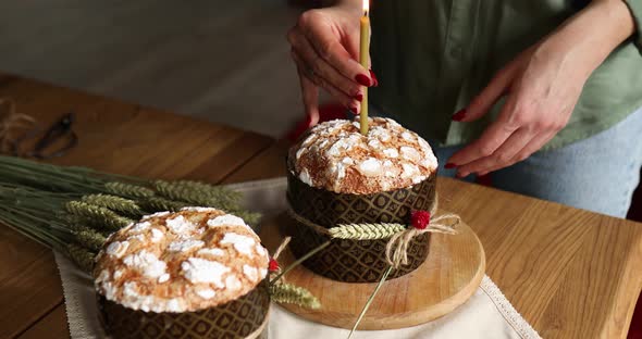 Happy Easter, Woman lighting candle in Easter cake,