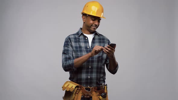 Indian Builder in Helmet Calling on Smartphone