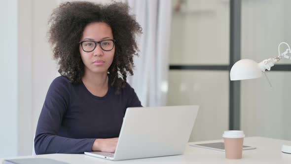 African Woman with Laptop Looking at Camera