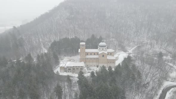 Drone view of shrine building nestled in the forest in Wisconsin. Pine trees surrounding church.