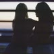 Two girls hugging and having drinks on the balcony with a city view - VideoHive Item for Sale