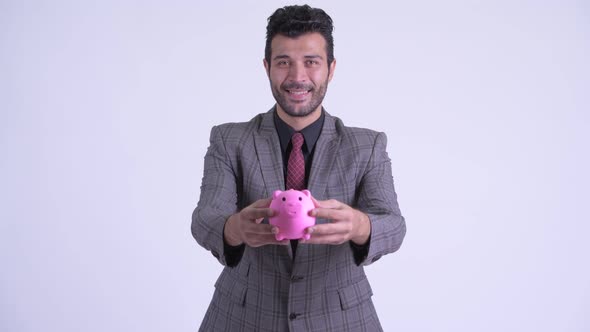 Happy Bearded Persian Businessman Giving Piggy Bank