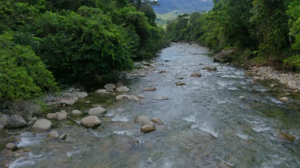 Aerial view, flying over a mountain river with clear ice cold blue water