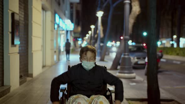 Handicapped child in wheelchair outside in the evening