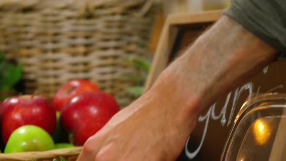 Male staff arranging strawberries in organic section