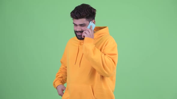 Happy Young Overweight Bearded Indian Man Talking on the Phone