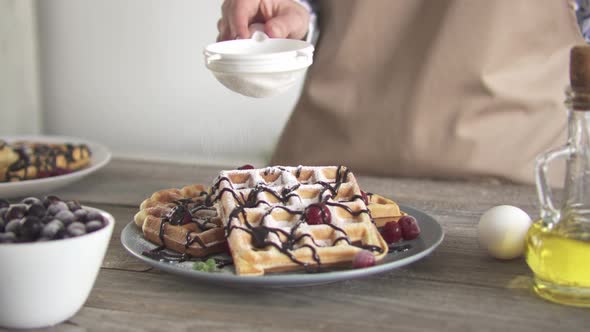 Topping With Powdered Belgian Waffles. White Powder Falls On Baked Goods.