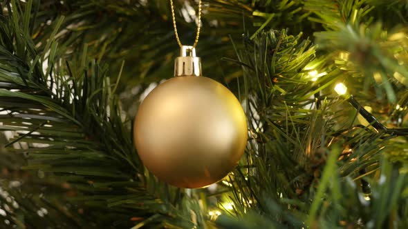 Golden Christmas ornament  with fairy lights close-up 4K 2160p 30fps UltraHD footage - Matte gold co