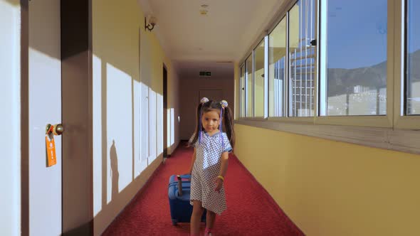 A Little Girl Is Walking Around the Hotel with a Children's Suitcase