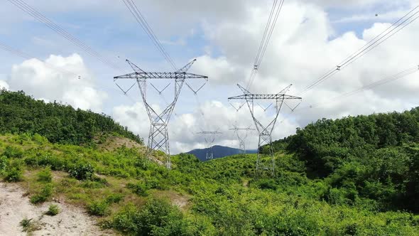 Tilt Up Aerial Shot Electricity Transmission Power Lines Pass Through The Forest.