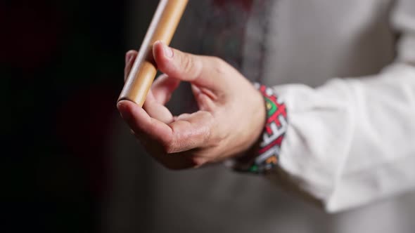 Hand of Man Playing on Woodwind Wooden Flute  Ukrainian Telenka or Tylynka on Dark Background