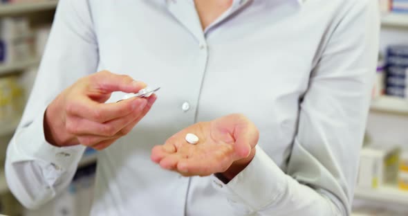 Pharmacist taking pills in pharmacy