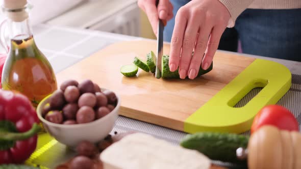 Greek Salad Preparation Series Concept  Woman Cutting Cucumbers