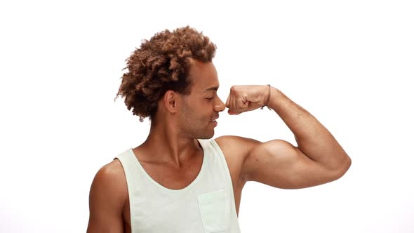 Man Smiling Showing Muscles Kissing Biceps Over White Background Slow Motion
