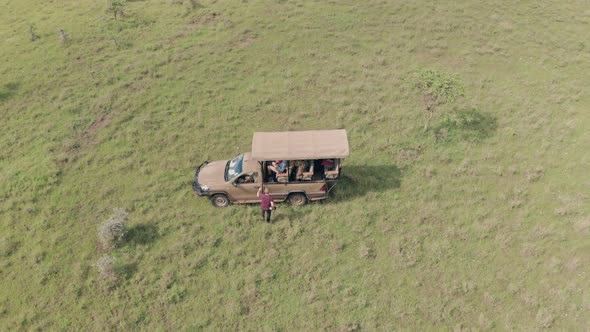 Man gets into 4 wheel drive vehicle after walking safari vacation in Laikipia, Kenya. Aerial drone v