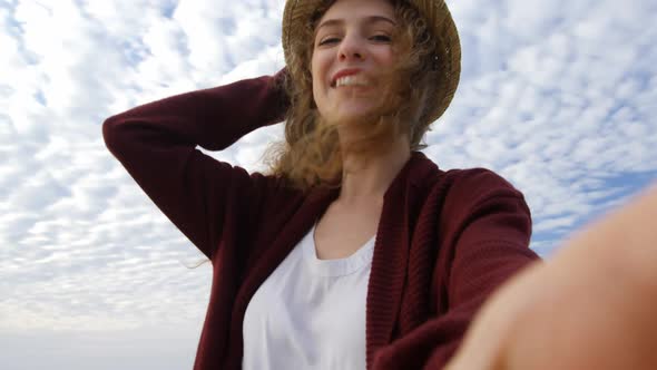 Low angle view of young beautiful caucasian woman in hat smiling an looking at camera 4k