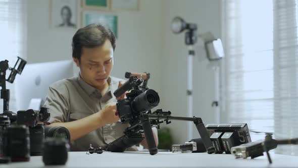 An Asian man is removing a series of camera rigs