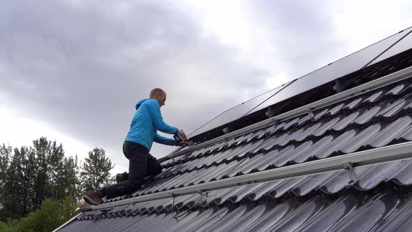 Technician fastening solar panels on rooftop during installation process - Static with male worker i