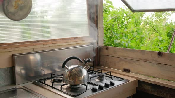 Steam Coming Out of the Kettle in Summer Countryside Kitchen.