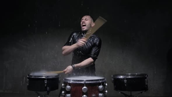 Drummer Playing Drums with Water in a Dark Studio
